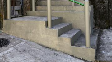 escadaria em morro, recém-construída, com corrimãos. #paratodosverem 