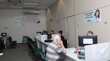 Senhor, sentado, é atendido por profissional da Sala do Empreendedor. #pratodosverem