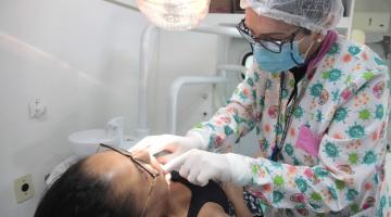 Mulher é atendida por dentista. #pratodosverem