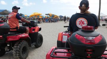 dois enfermeiros dirigem quadriciclo do samu na areia. #paratodosverem