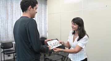 servidora entrega número a rapaz #paratodosverem 