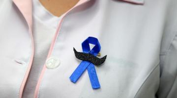 enfermeira com broche do novembro azul #paratodosverem 