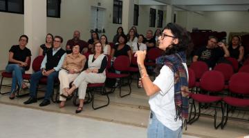 mulher fala para pessoas no auditório #paratodosverem