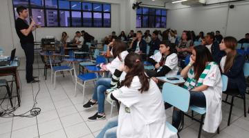 sala de aula com várias pessoas sem máscara. #paratodosverem