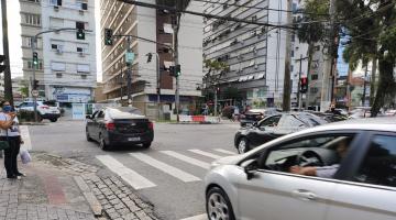 rua com carros passando e semáforo à frente. #paratodosverem