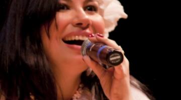 A cantora Simone Ancelmo com o microfone junto à boca em foto de close. #Pracegover