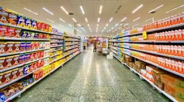 corredor de supermercado com gôndolas cheias de produtos dois dois lados. #paratodosverem 
