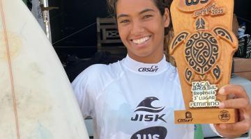 jovem surfista mulher mostra prancha e troféu #paratodosverem