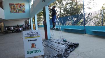 operário faz manutenção em parede de escola #pracegover