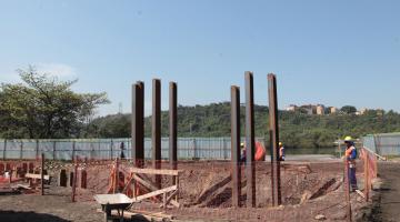 Seis pilares em evidência em terreno com escavações. #Pracegover