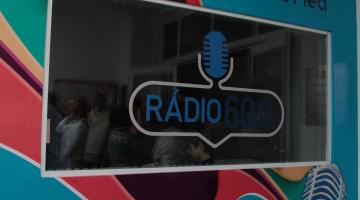 Fachada da rádio com parede colorida e um vidro que torna possível ver de fora para dentro e vice-versa. #Pracegover