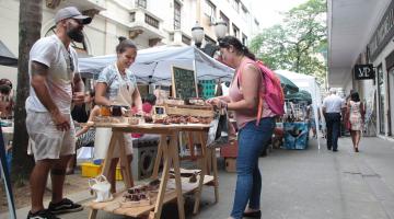 Mulher olha produtos expostos em banca #pracegover 