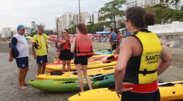 alunos na areia se preparando para aula de canoagem #pracegover 