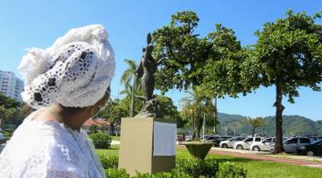 mulher vestida a caráter olha estátua #paratodosverem 