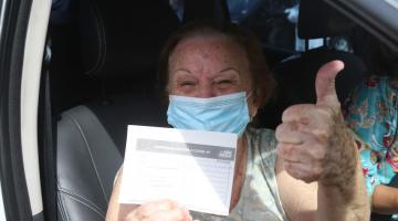 mulher mostra certificado de vacinação #paratodosverem