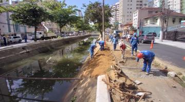 homens estão fazendo obras em talude de canal. #paratodosverem 