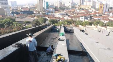 Operários realizam impermeabilização de cobertura. #pracegover