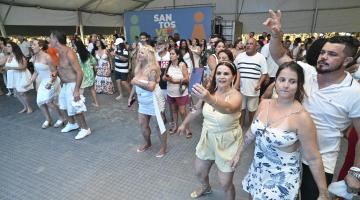 público dança animada sob tenda. #paratodosverem