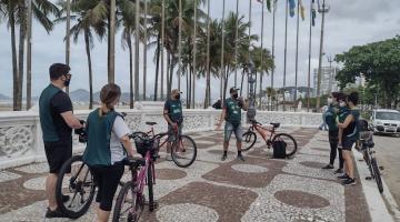 ciclista estão desmontados das bikes na praça das bandeiras. Umdeles fala ao grupo. #paratodosverem