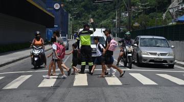agente ajuda crianças a atravessar a rua #paratodosverem 
