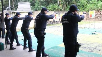 guardas estão enfileirados, todos segurando armas com mãos estendidas e apontando para alvos no fundo de uma espécie de quadra. #paratodosverem