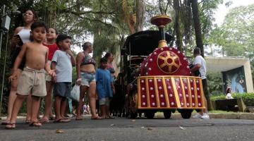 pessoas perto do trenzinho no jardim botânico #paratodosverem 
