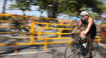 ciclista de bicicleta e ao fundo arvores e visual borrado #paratodosverem
