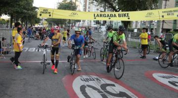 atletas pegando bicicleta durante a prova #paratodosverem 