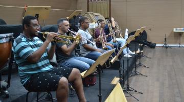 Wellinghton de Oliveira Santos está trocando trompete com outros músicos. #Paratodosverem