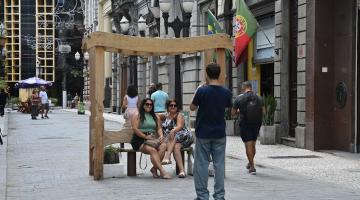 pessoas sentadas em banco no centro #paratodosverem
