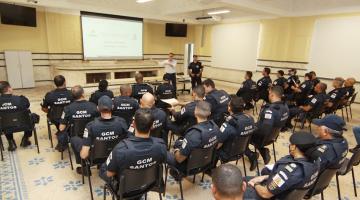 guardas estão sentados em auditório assistindo palestra. Todos estão de costas para a foto.. #paratodosverem