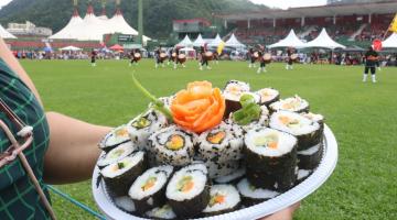 prato de comida japonesa com dança ao fundo #paratodosverem