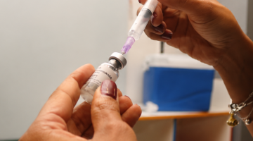 mãos preparam seringa para vacinação #paratodosverem