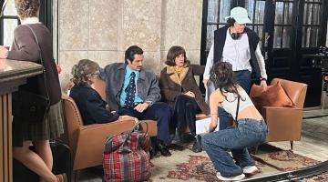 atores sentados em sofa para gravação de filme. #paratodosverem