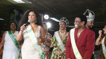 três pessoas se apresentando. uma mulher com microfone em mãos #paratodosverem