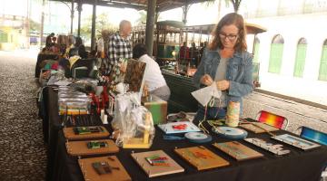 pessoas olhando produtos em feira criativa #paratodosverem