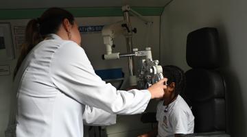 médica analisa olhos de menina #paratodosverem