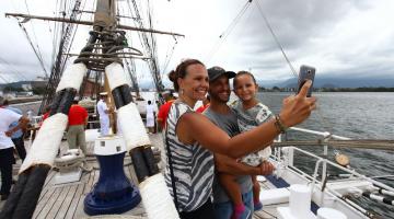 Casal e criança tiram selfie dentro de navio veleiro. #paratodosverem