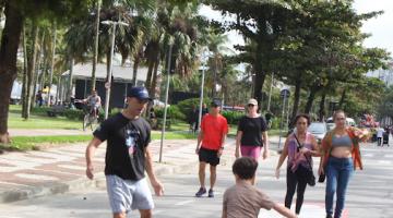 pessoas na orla caminhando e jogando futebol #paratodosverem 