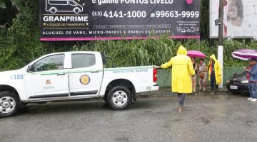 viatura da defesa civil em área de risco em dia de chuva. Agentes com capas amarelas estão na área. #paratodosverem