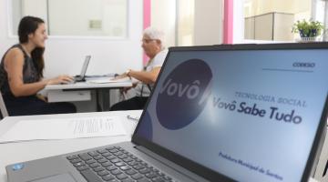 idosa faz inscrição com computador em primeiro plano #paratodosverem