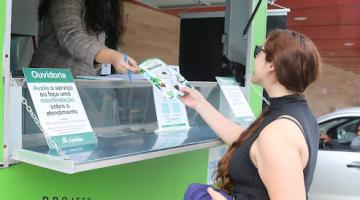 pessoa recebe panfleto de atendente na unidade móvel #paratodosverem