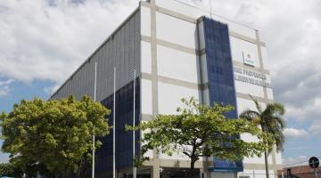 Fachada de escola com árvores na frente. #Paratodosverem