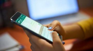 mão segurando celular com tela do whatsapp #paratodosverem