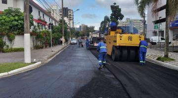 máquina e operários atuam na pavimentação #pracegover