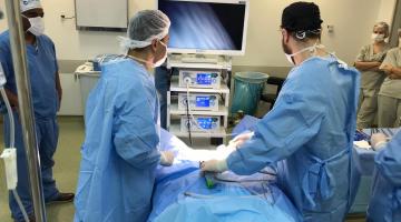 dois médicos durante a operação olham monitor #pracegover 