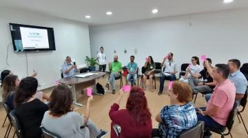 Pessoas estão reunidas em salão. Elas conversam. #Pracegover