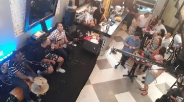 banda toca e convidados estão em pé na pista #pracegover