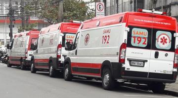 Três ambulâncias estacionados em rua. #Pracegover