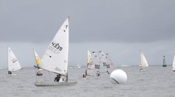 #pracegover Oito barcos à vela navegam pelo mar próximos a boia branca de marcação